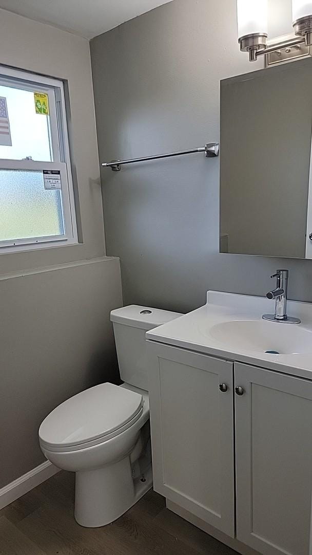 bathroom featuring vanity, toilet, and hardwood / wood-style floors