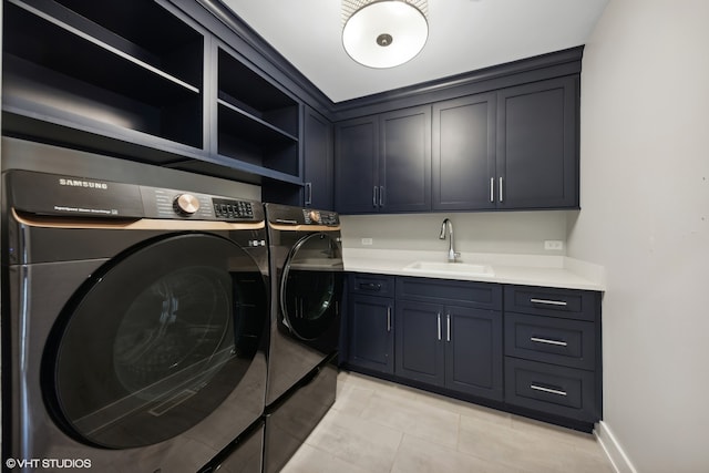 laundry room with light tile patterned floors, cabinets, sink, and washing machine and clothes dryer