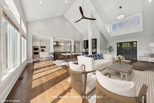 living room featuring wood-type flooring, high vaulted ceiling, and ceiling fan