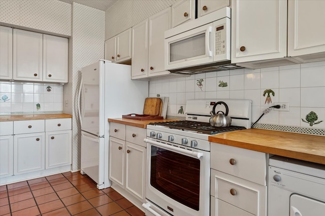 kitchen featuring wood counters, white appliances, white cabinetry, washer / clothes dryer, and decorative backsplash