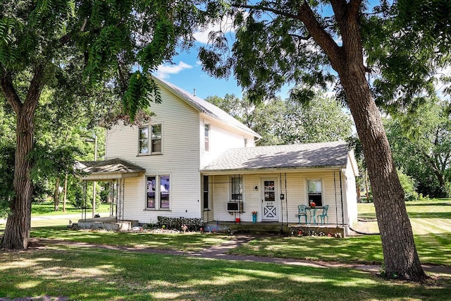 view of front of property featuring a front yard, covered porch, and cooling unit