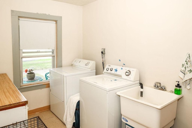 clothes washing area with washer and clothes dryer and sink