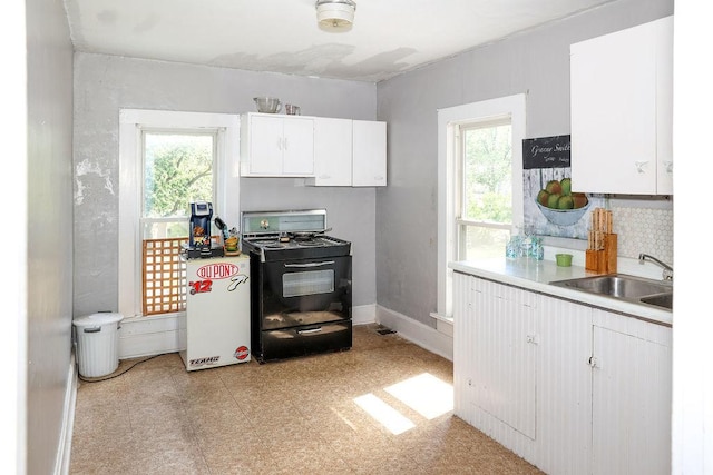 kitchen featuring black stove, white cabinets, and sink