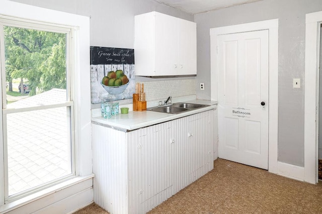 kitchen with white cabinetry, sink, decorative backsplash, and a healthy amount of sunlight