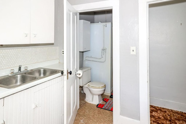 bathroom featuring vanity, backsplash, and toilet