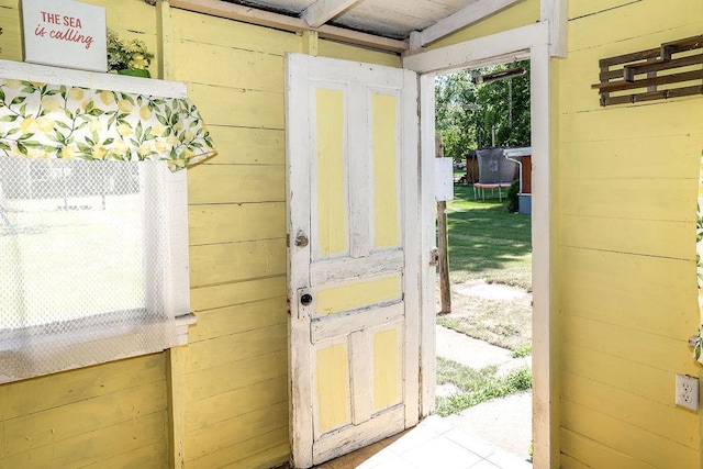 entryway with wood walls