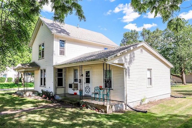 view of front of property with cooling unit, covered porch, and a front lawn