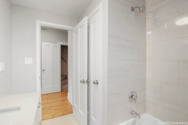 bathroom with vanity, tiled shower / bath, and hardwood / wood-style floors