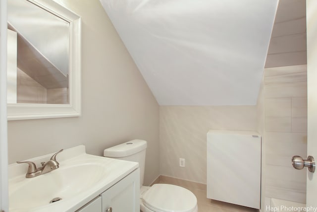 bathroom featuring vaulted ceiling, vanity, and toilet