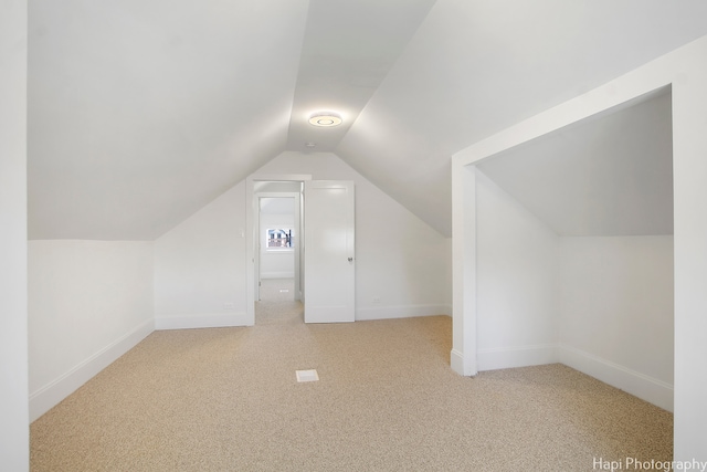 bonus room with light carpet and lofted ceiling