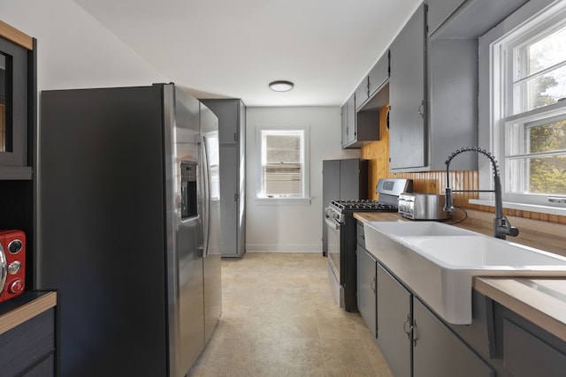 kitchen featuring gray cabinetry, stainless steel appliances, sink, and a wealth of natural light