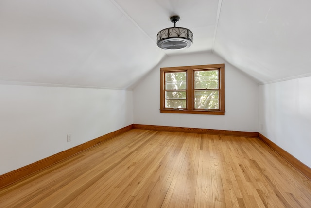 bonus room with vaulted ceiling and light wood-type flooring