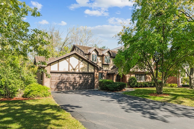 english style home with a garage and a front yard