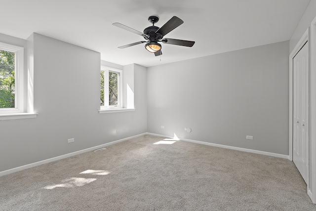 unfurnished bedroom with ceiling fan, light colored carpet, and a closet