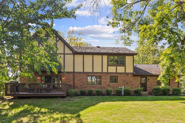 rear view of house with a wooden deck and a yard