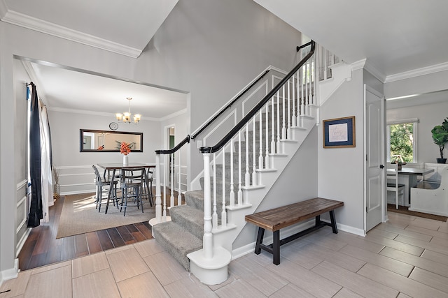 staircase featuring an inviting chandelier and ornamental molding