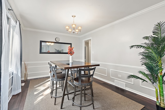 dining room featuring ornamental molding, dark hardwood / wood-style flooring, and a notable chandelier