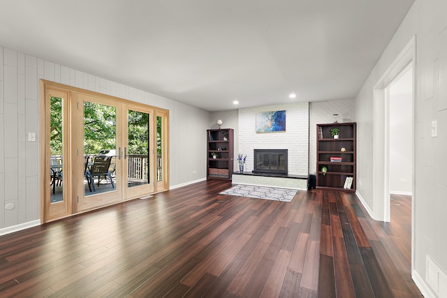 unfurnished living room featuring a fireplace and dark wood-type flooring