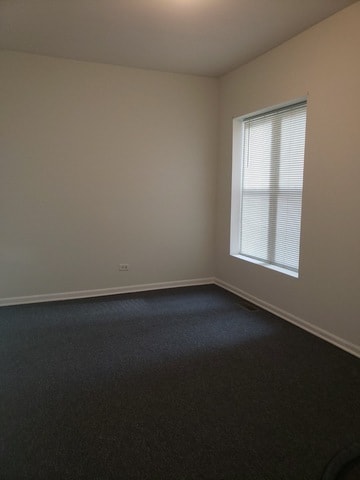 empty room featuring dark colored carpet