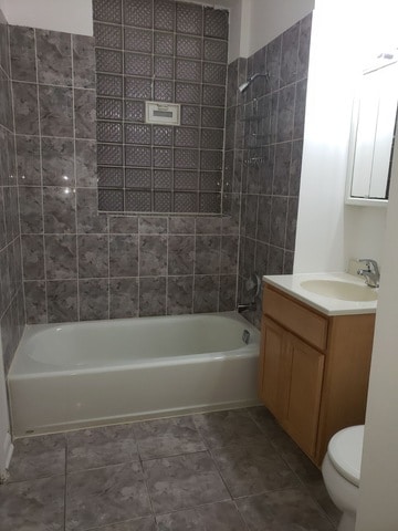 full bathroom with vanity, toilet, tiled shower / bath, and tile patterned floors