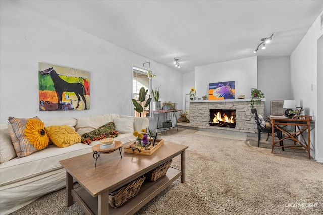 carpeted living room with track lighting and a fireplace