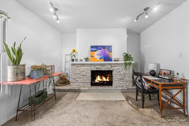 carpeted living room with track lighting and a fireplace