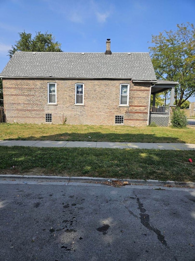 view of side of home with a yard