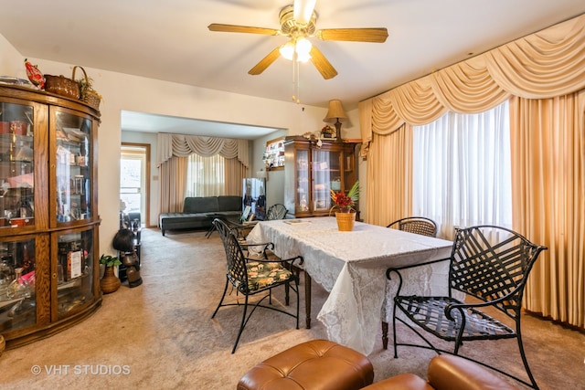 carpeted dining area featuring ceiling fan