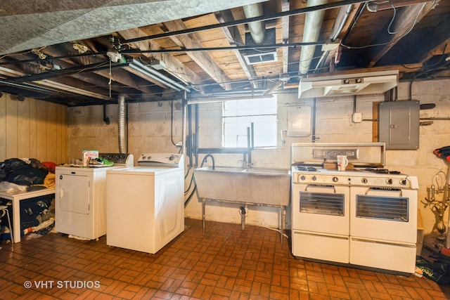 interior space with sink, electric panel, and washing machine and clothes dryer