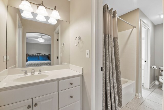 full bathroom with shower / tub combo with curtain, tile patterned flooring, vanity, ceiling fan, and toilet