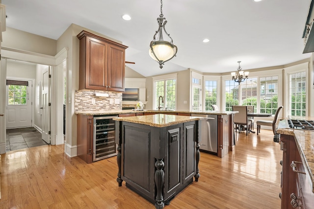 kitchen featuring a kitchen island, sink, beverage cooler, stainless steel dishwasher, and kitchen peninsula