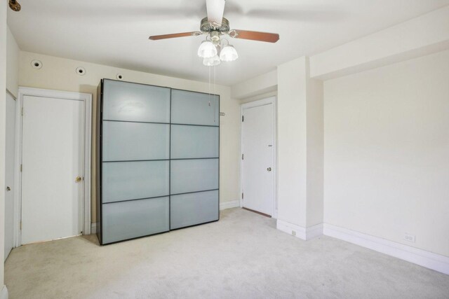 unfurnished bedroom featuring light carpet and ceiling fan