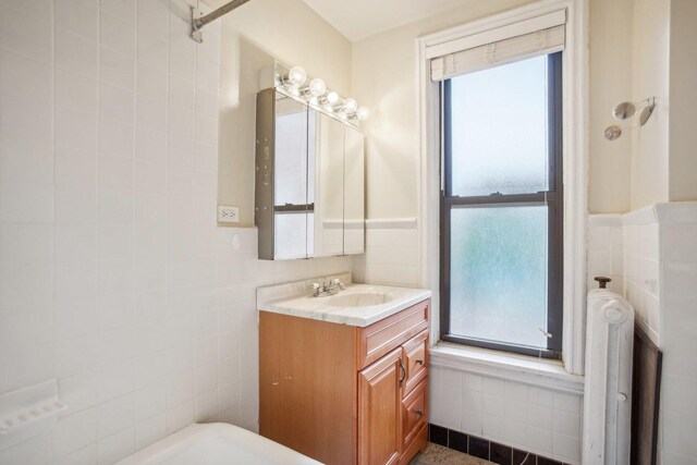 bathroom with vanity and tile walls