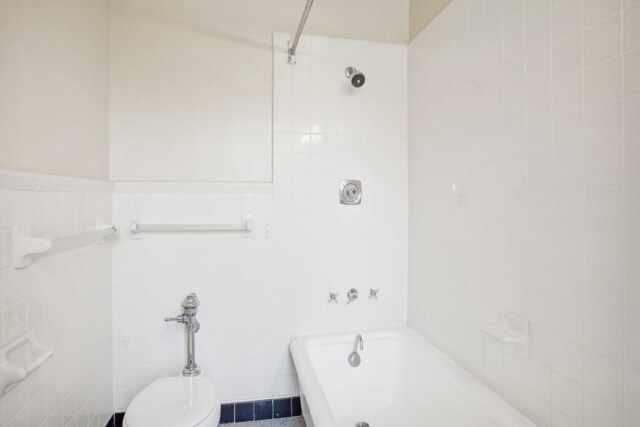 bathroom with tile walls and toilet