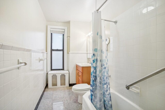 full bathroom with shower / tub combo with curtain, vanity, toilet, and tile walls