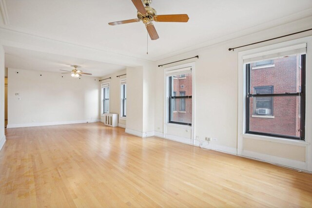 unfurnished room with radiator, light hardwood / wood-style flooring, and ceiling fan