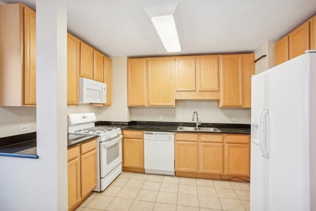 kitchen featuring sink, white appliances, light tile patterned floors, and light brown cabinets