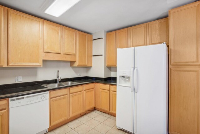 kitchen featuring light brown cabinetry, sink, white appliances, and light tile patterned flooring