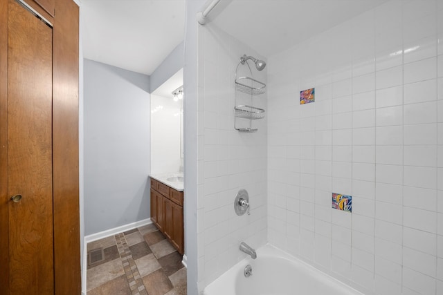 bathroom with tile patterned flooring, tiled shower / bath combo, and vanity