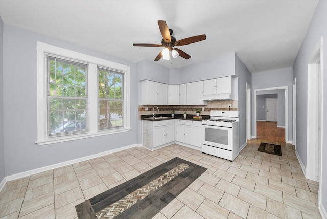 kitchen featuring tasteful backsplash, white gas range, ceiling fan, sink, and light tile patterned floors