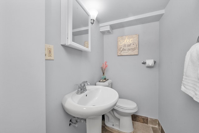 bathroom with toilet and tile patterned floors