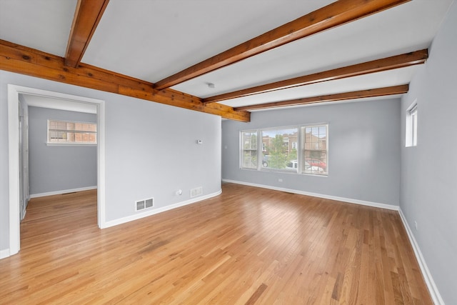 unfurnished living room featuring light hardwood / wood-style floors and beam ceiling