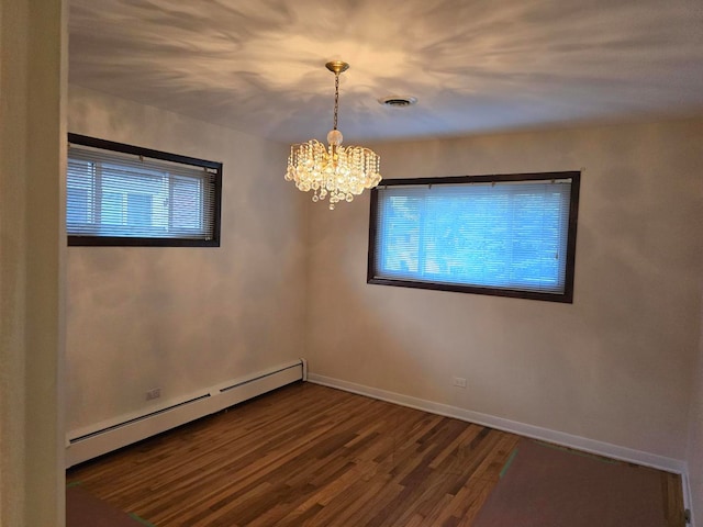 empty room with a wealth of natural light, baseboard heating, a chandelier, and dark hardwood / wood-style floors