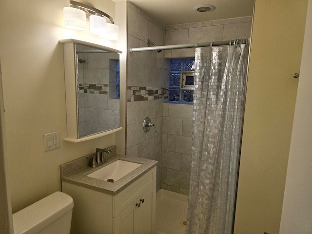 bathroom featuring vanity, toilet, and walk in shower