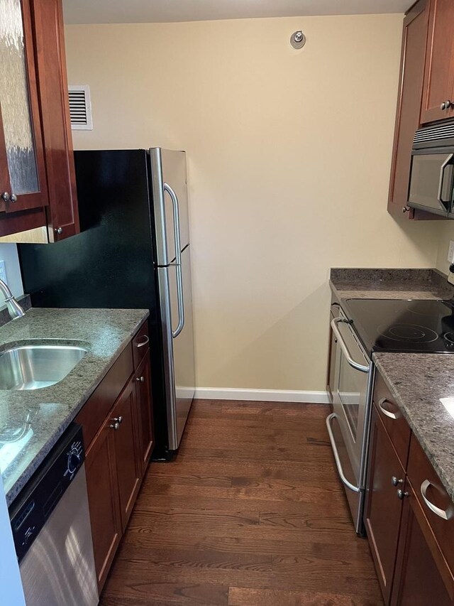 kitchen featuring sink, appliances with stainless steel finishes, stone counters, and dark hardwood / wood-style flooring