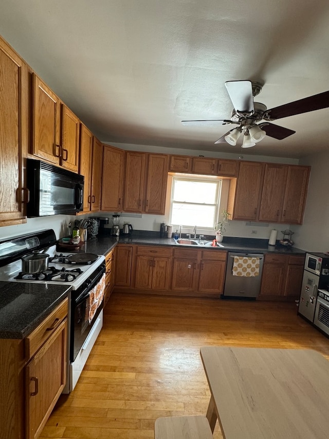 kitchen featuring ceiling fan, dishwasher, light wood-type flooring, sink, and gas range gas stove