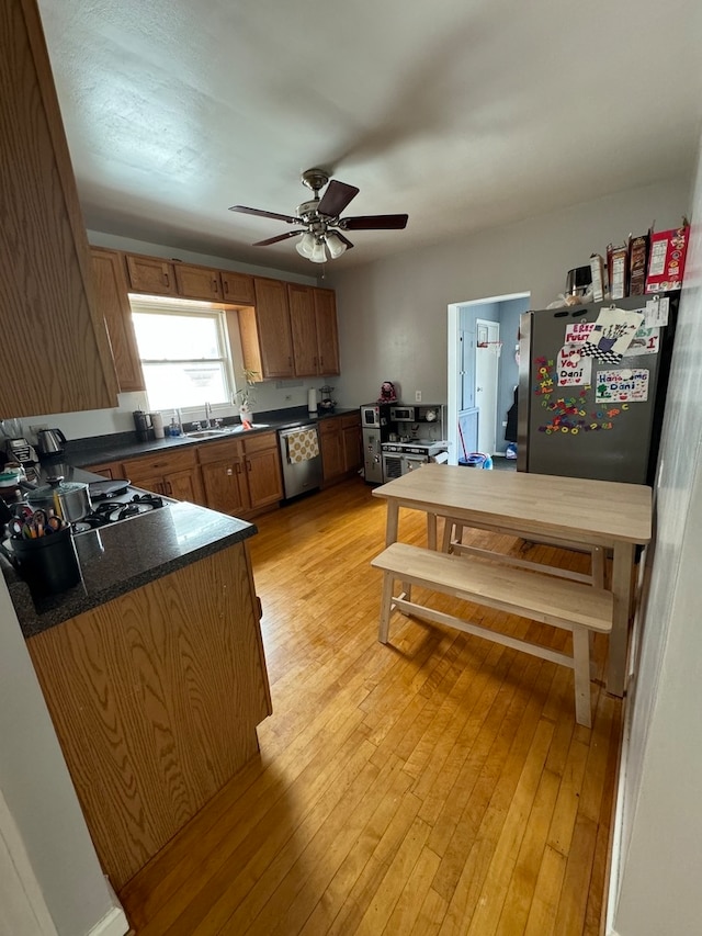 kitchen featuring ceiling fan, light wood-type flooring, and stainless steel appliances