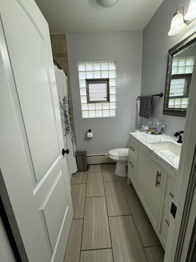 bathroom featuring a baseboard radiator, toilet, tile patterned floors, and vanity