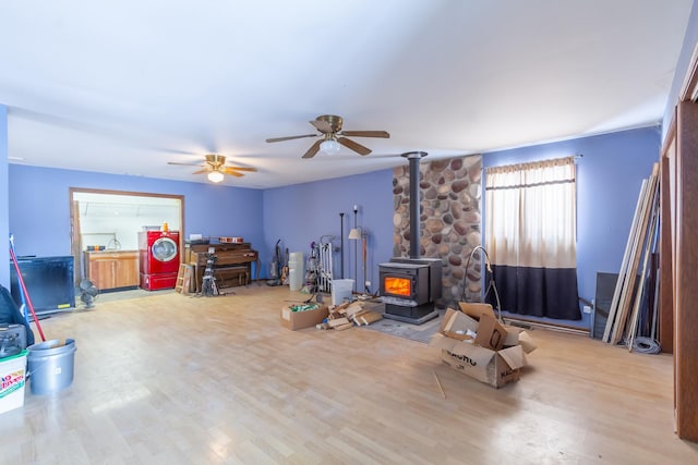 recreation room with a wood stove and wood finished floors