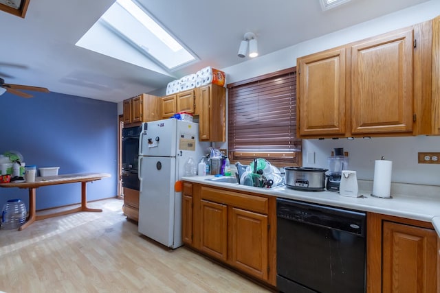 kitchen with light wood-style flooring, light countertops, dishwasher, and freestanding refrigerator